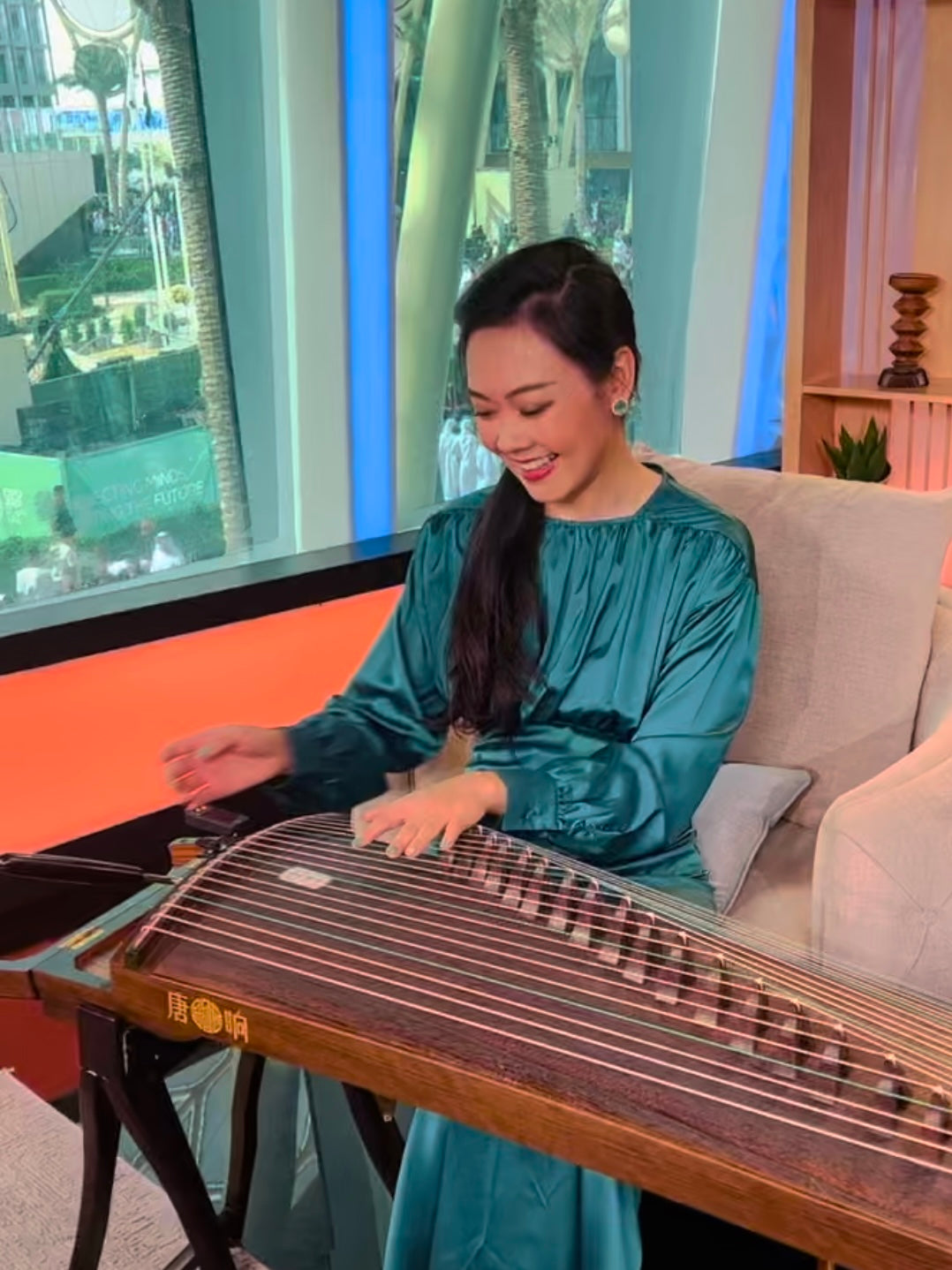 Founder of Guzheng World Qing Du testing and comparing guzhengs to help students choose the right instrument with confidence worldwide